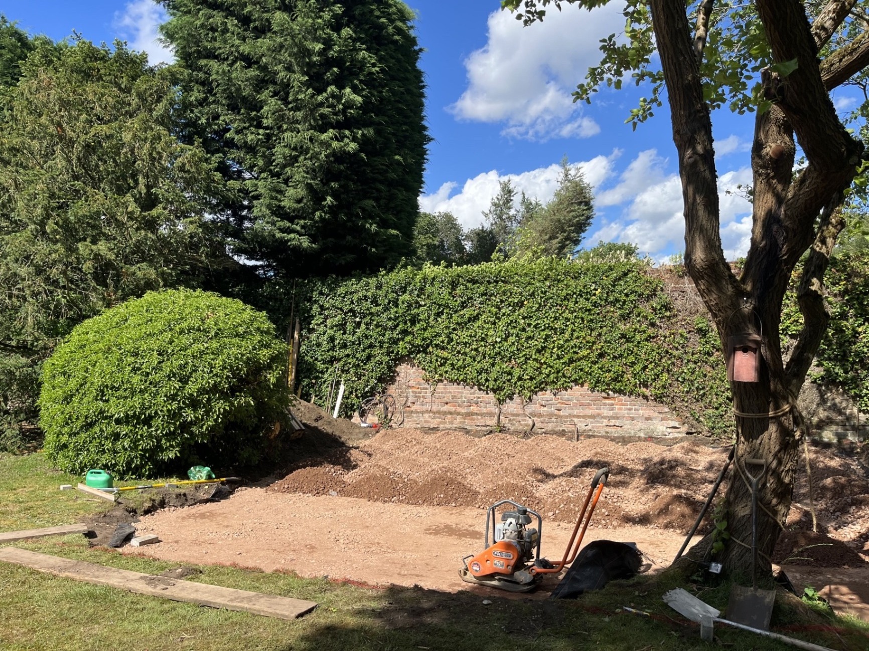 Compacted MOT Type 1 sub-base spread across the full patio area, ready for final preparation before laying porcelain