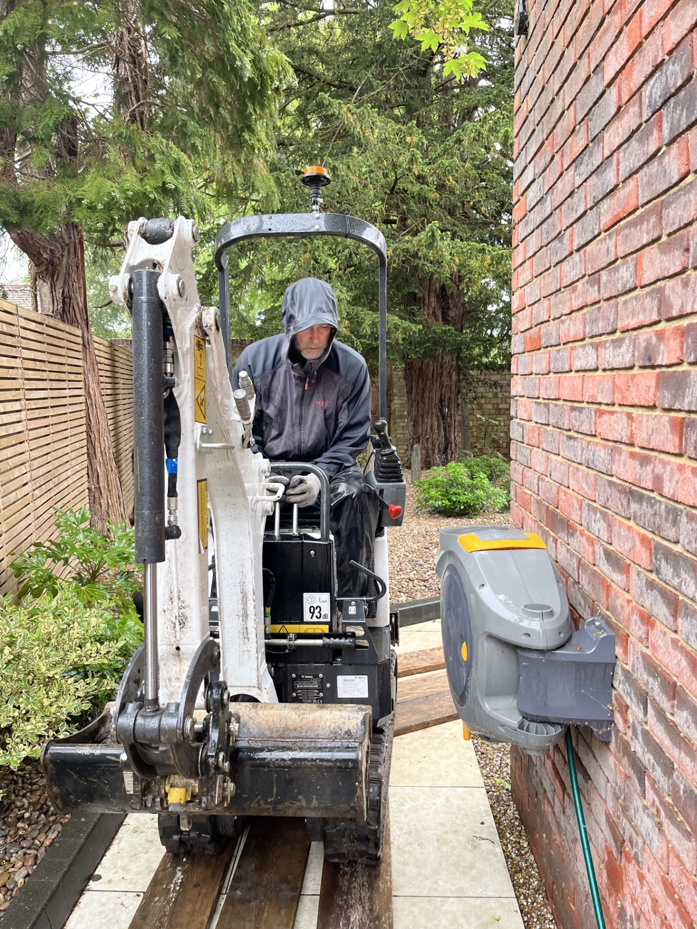 Micro digger working through tight access at the Godmanchester property during the early excavation stage of the porcelain patio build