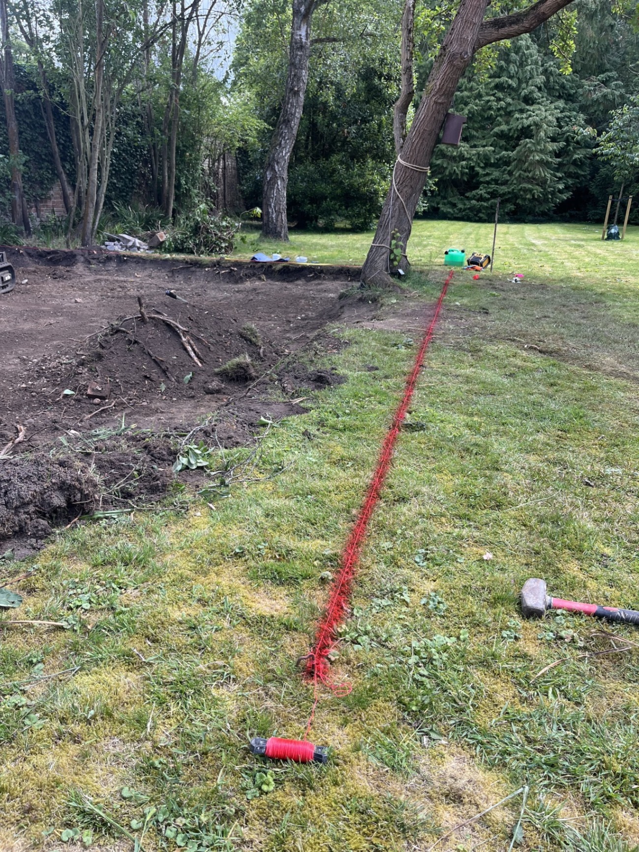 Setting out lines across the garden to establish the correct patio layout, levels and drainage falls around the site