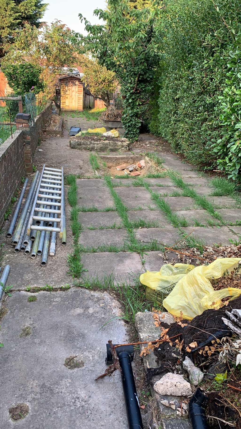 Tired weed-filled garden before block paving transformation in Fletton, Peterborough