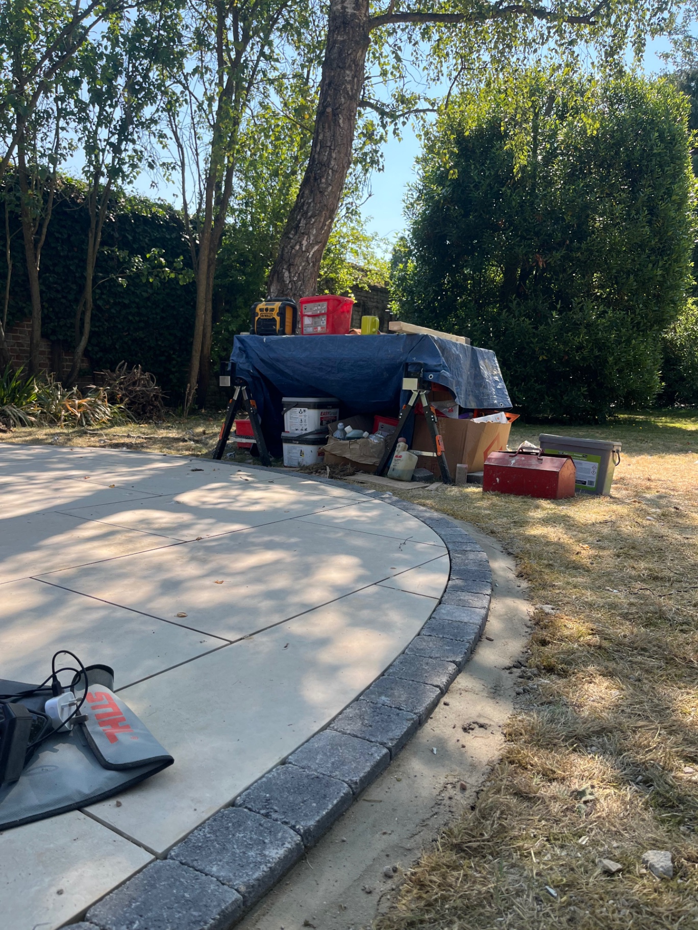 Completed curved porcelain patio edge with charcoal sett border in Godmanchester, Cambridgeshire