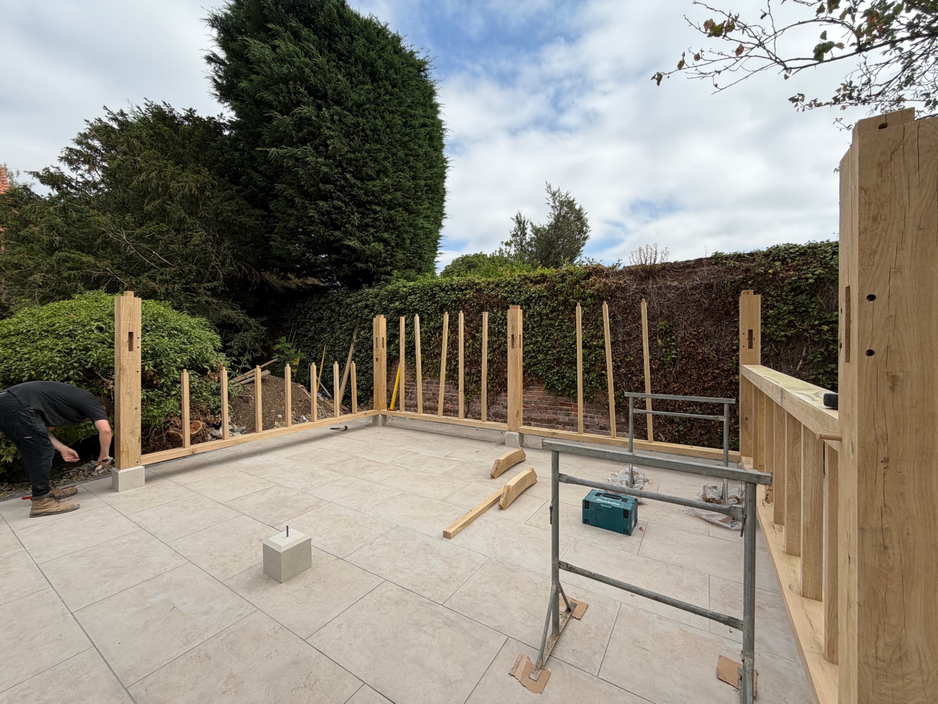 Oak gazebo posts and sole plates braced in position on the porcelain patio in Godmanchester