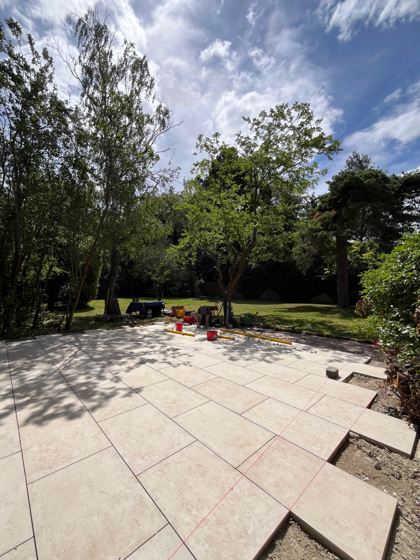 Porcelain patio with laser line set out across the slabs in the rear garden in Godmanchester