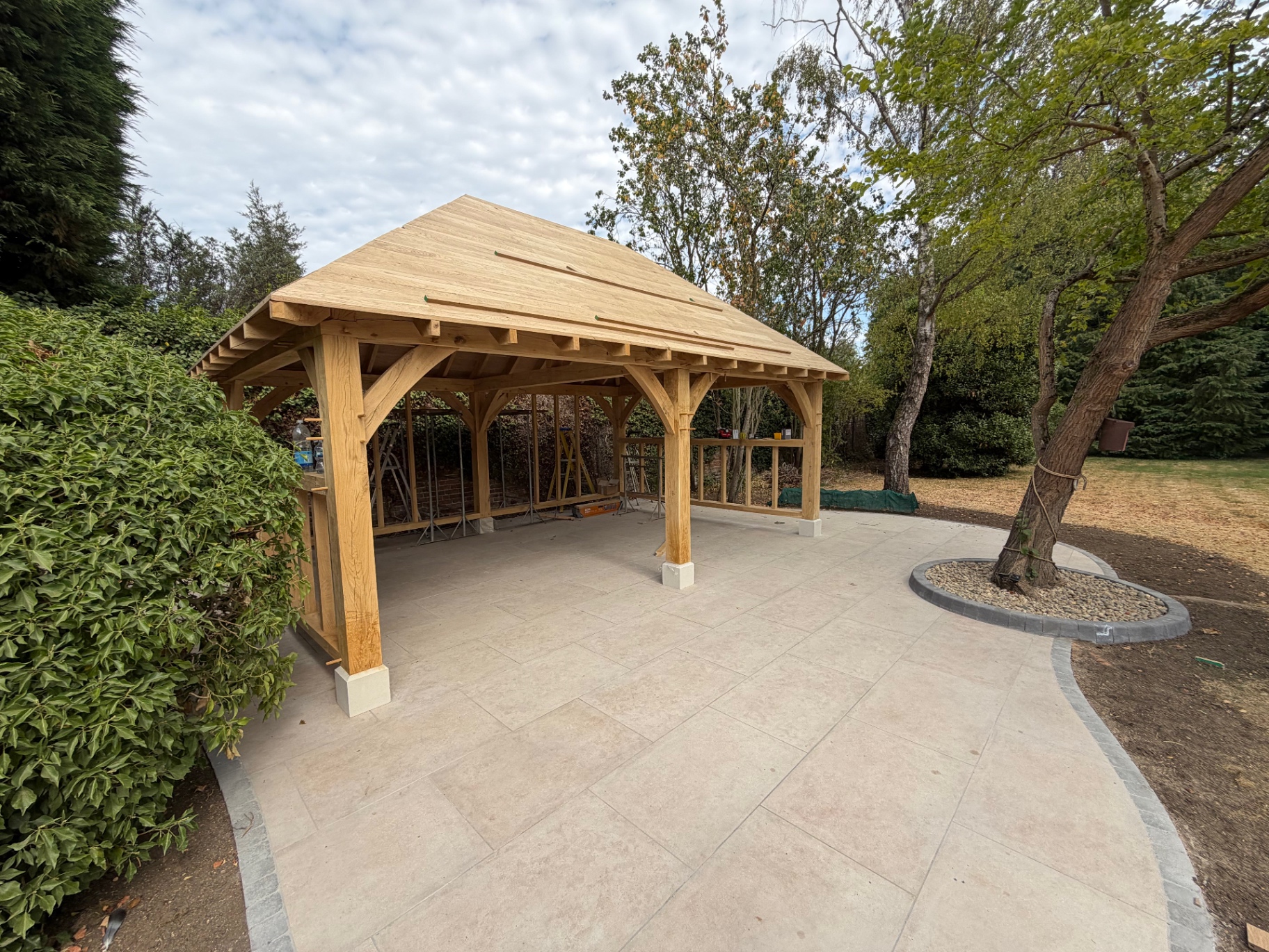 Oak gazebo with boarded roof standing over the porcelain patio in Godmanchester, Cambridgeshire