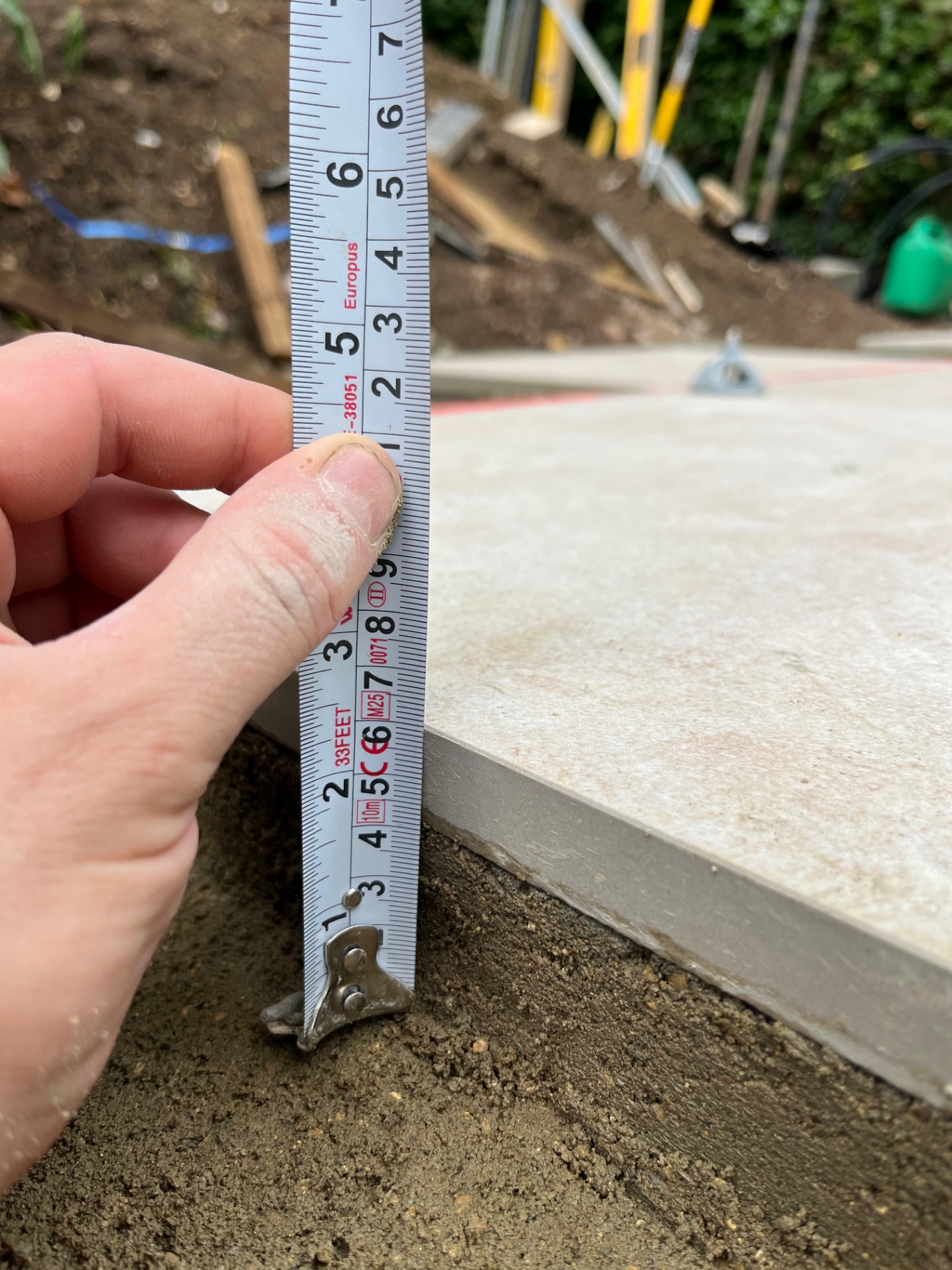 Tape measure showing the depth of the full mortar bed under a porcelain slab in Godmanchester