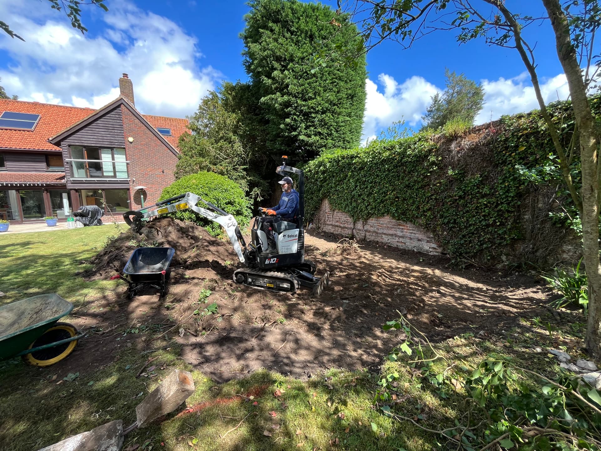 Digger clearing soil from the garden in Godmanchester