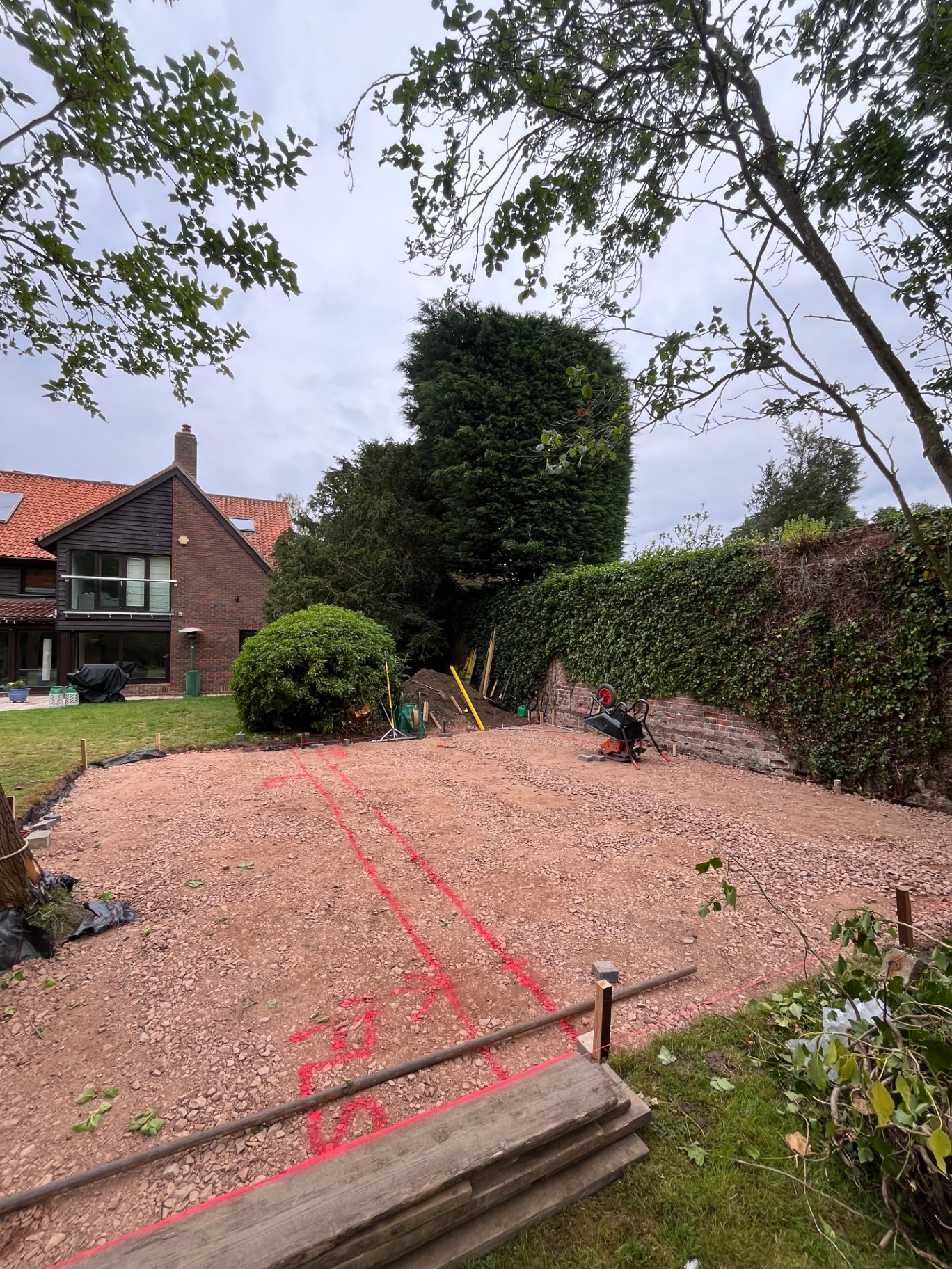 Patio and gazebo footprint marked out in red spray paint on the prepared base in Godmanchester