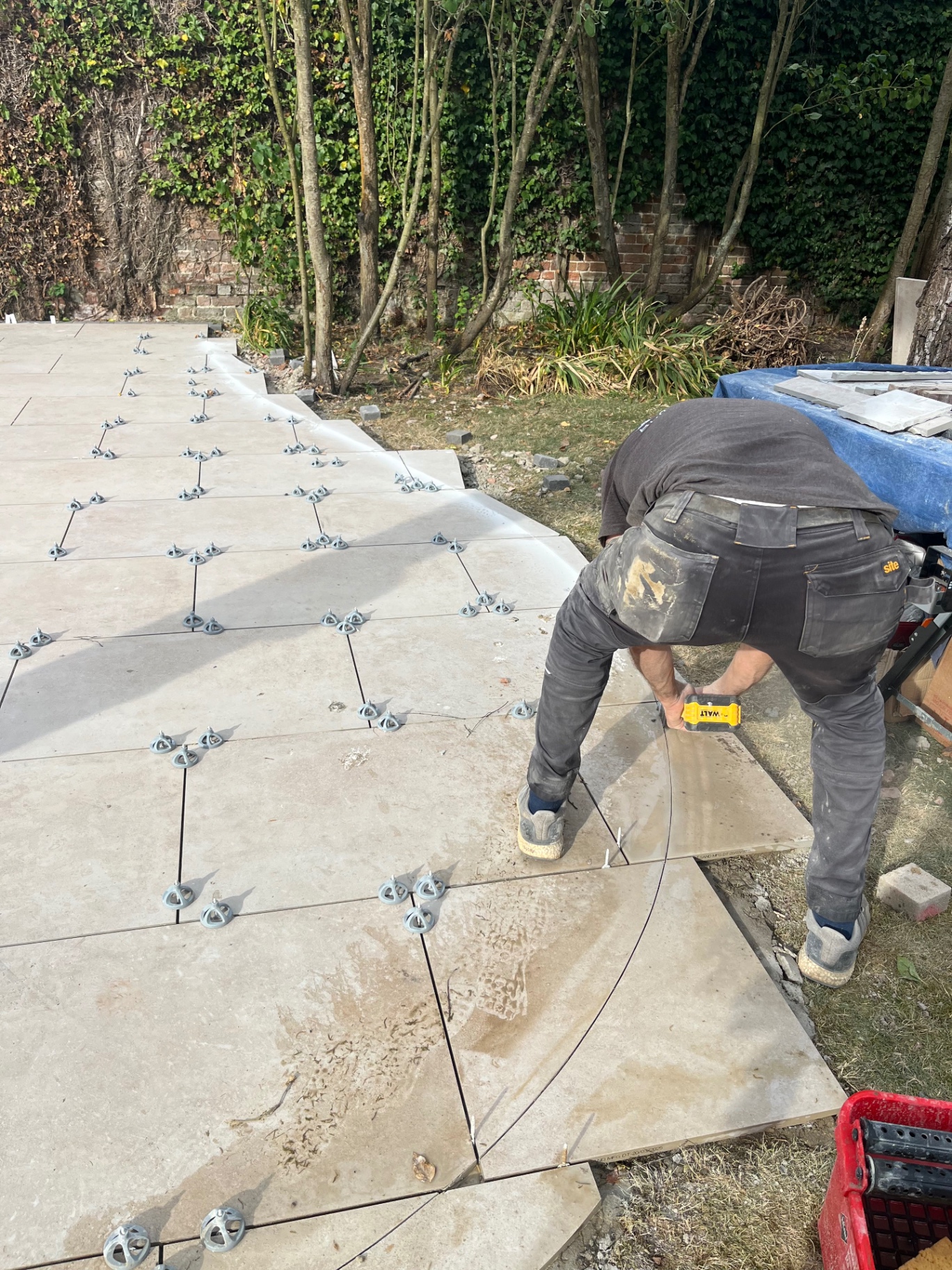 Landscaper marking a curved cut on a porcelain slab in Godmanchester, Cambridgeshire