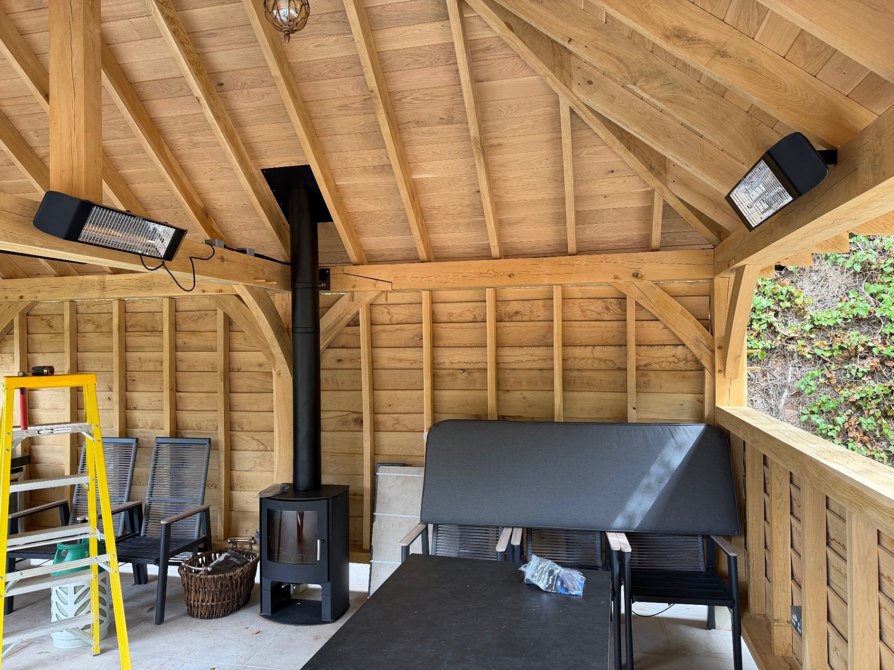 Log burner and seating inside the oak gazebo in Godmanchester, Cambridgeshire