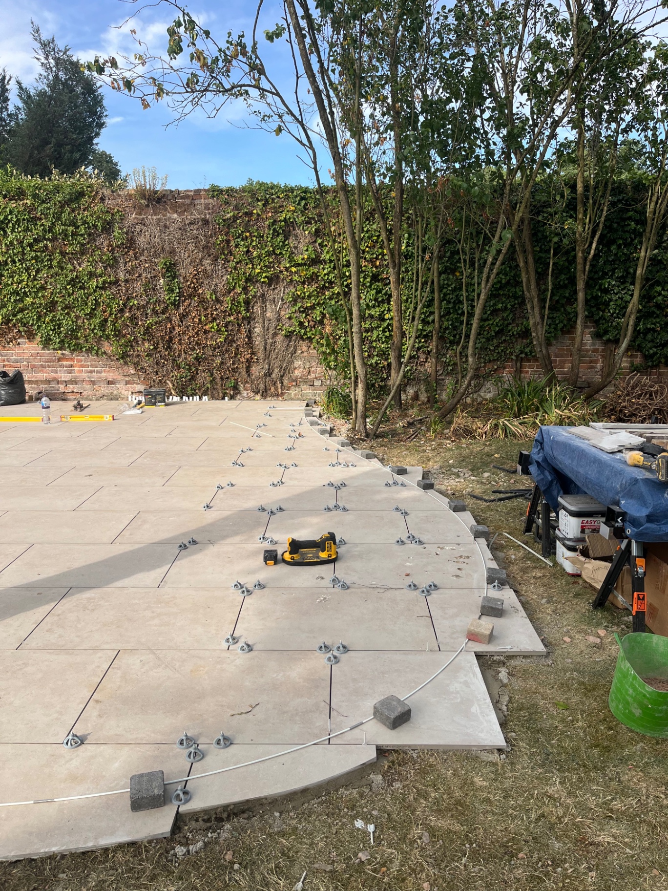 Curved edge of the porcelain patio marked out with a flexible line in Godmanchester
