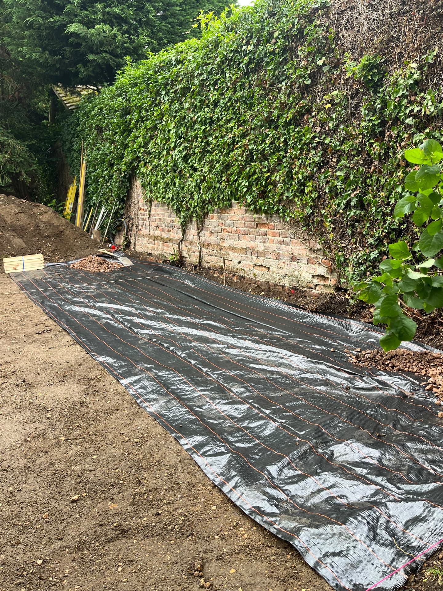Weed membrane laid across the excavated patio base in Godmanchester