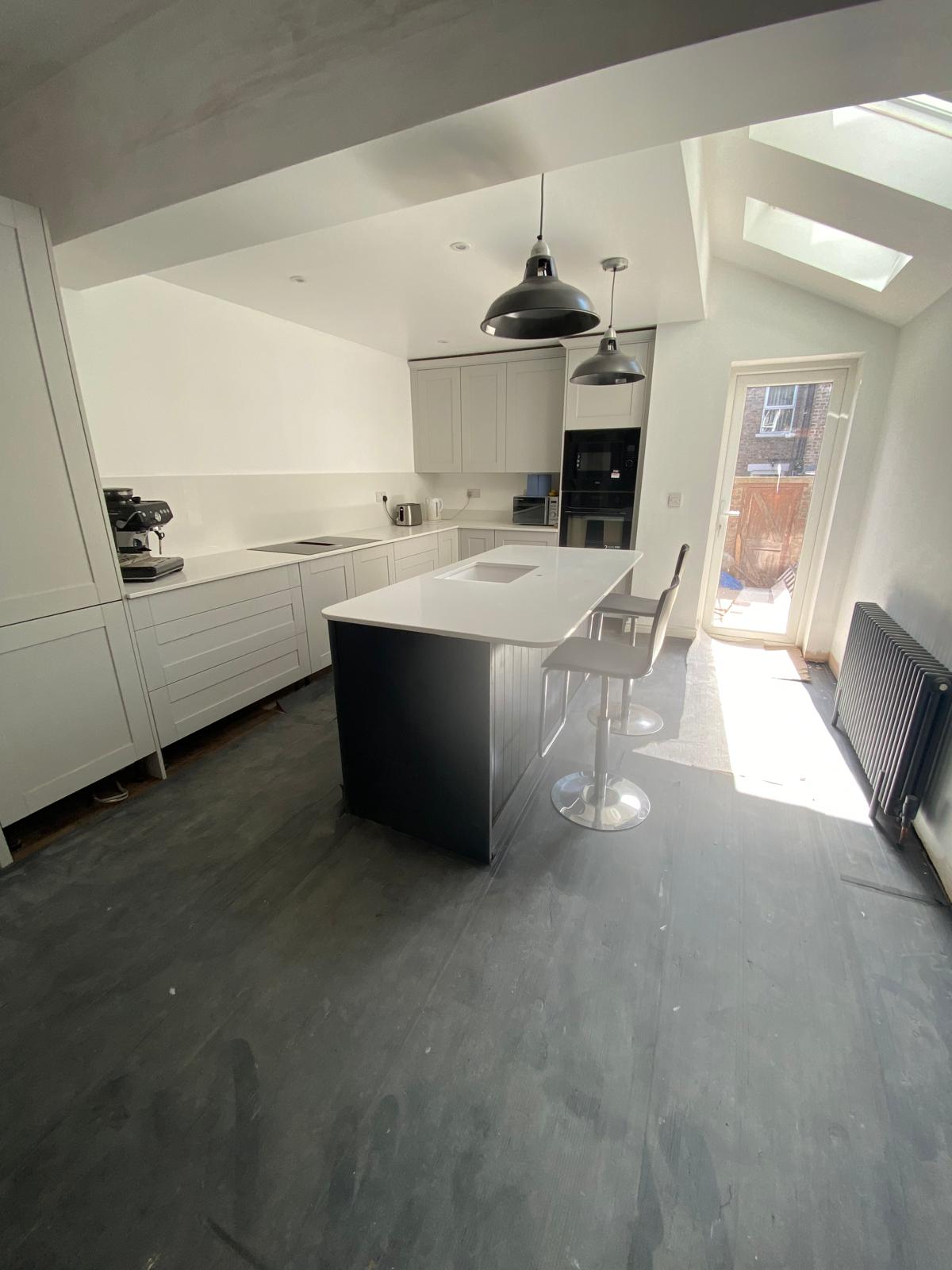 Finished open plan kitchen diner with island, pendant lights and Velux skylights in Cambridgeshire