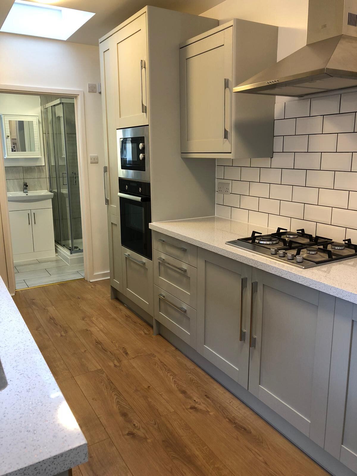 Renovated Bedford kitchen with shaker units, quartz worktops, metro tile splashback and skylit extension by Arcadia Build & Landscape