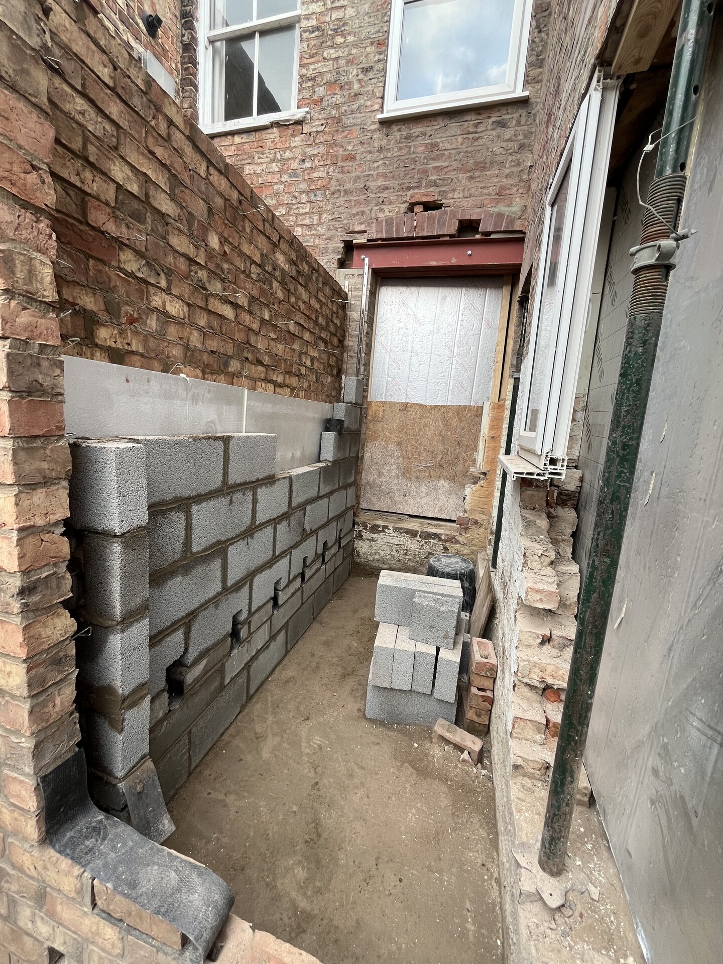 Internal blockwork wall with cavity ties and pipework on Cambridgeshire side extension