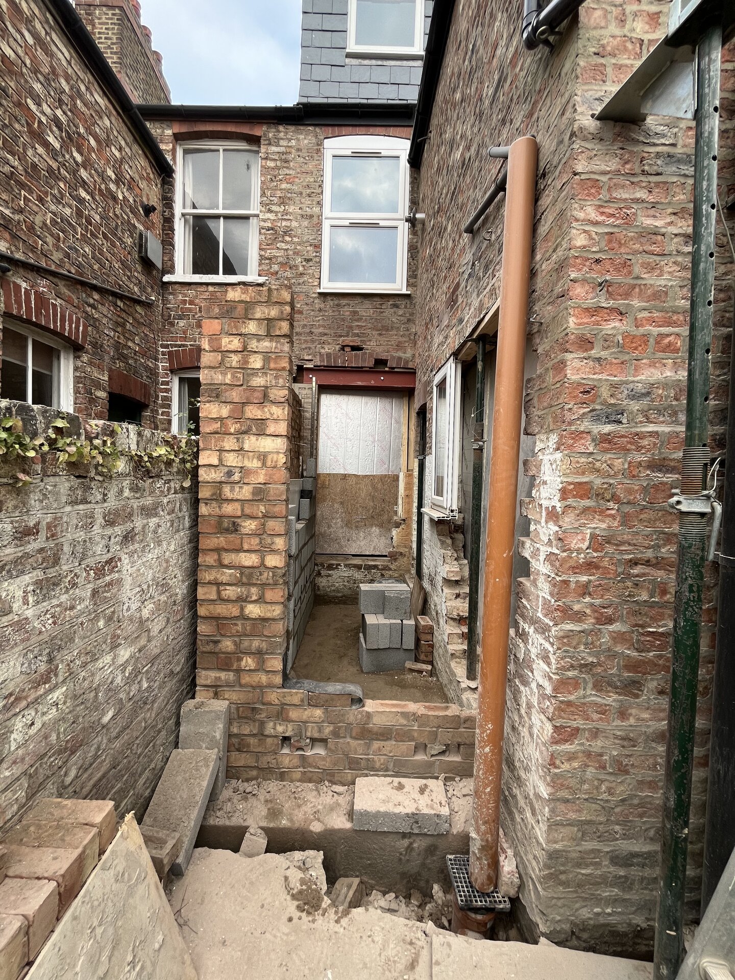 Brickwork building up around new external door opening on Cambridgeshire side extension