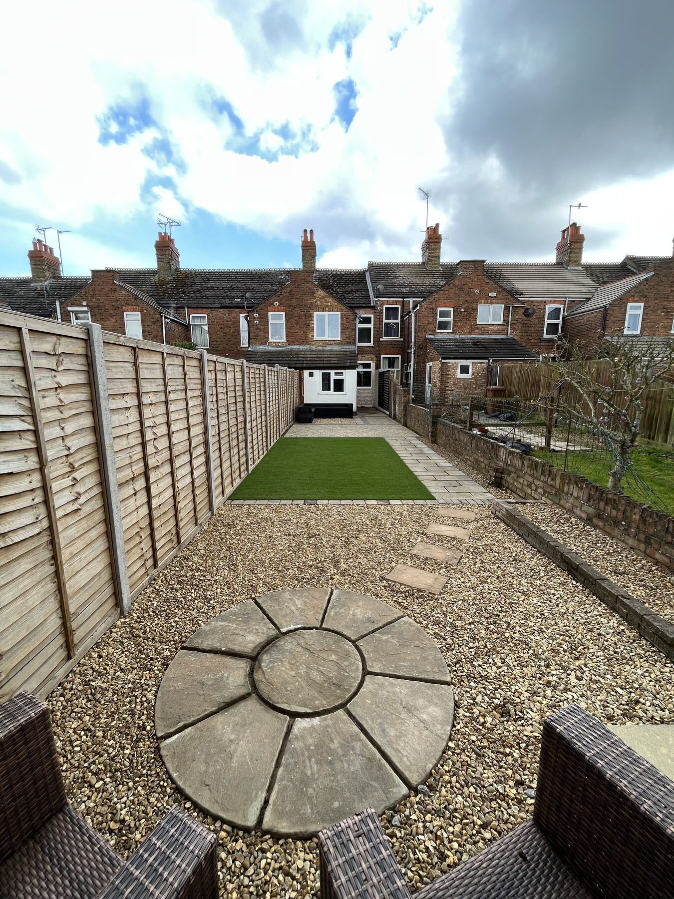 Reverse view of completed garden showing gravel area, stepping stones and artificial grass in Fletton