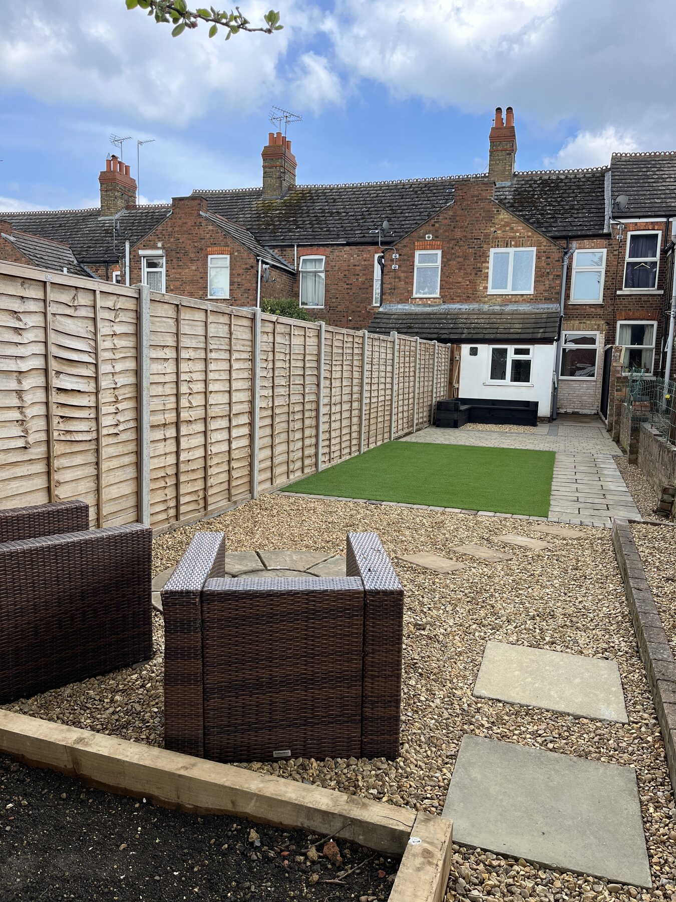 Rear seating area with stepping stones, gravel and rattan furniture in Fletton, Peterborough garden