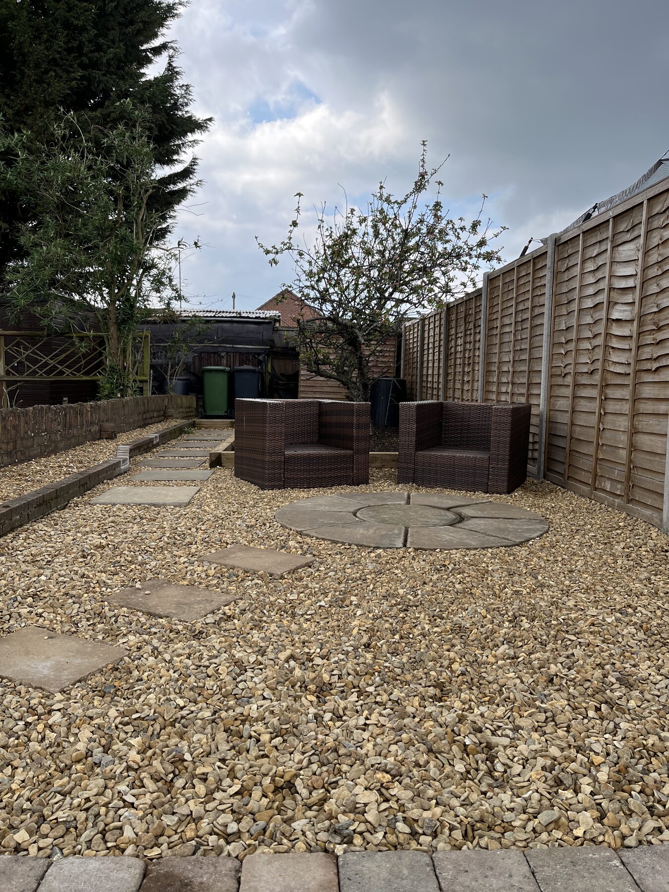 Detail of stone feature circle, gravel and rattan seating in completed Fletton garden