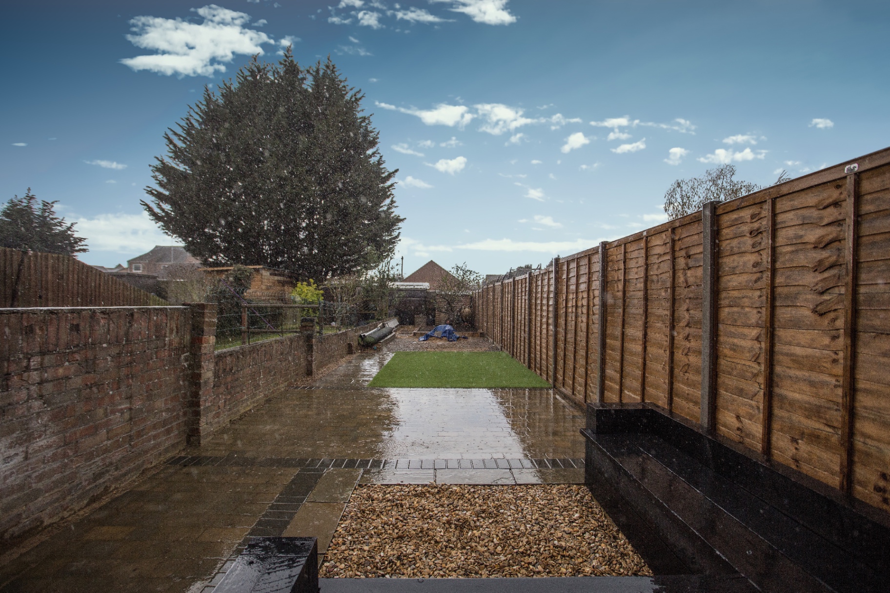 Wet block paving and new artificial grass area part way through Fletton, Peterborough garden transformation