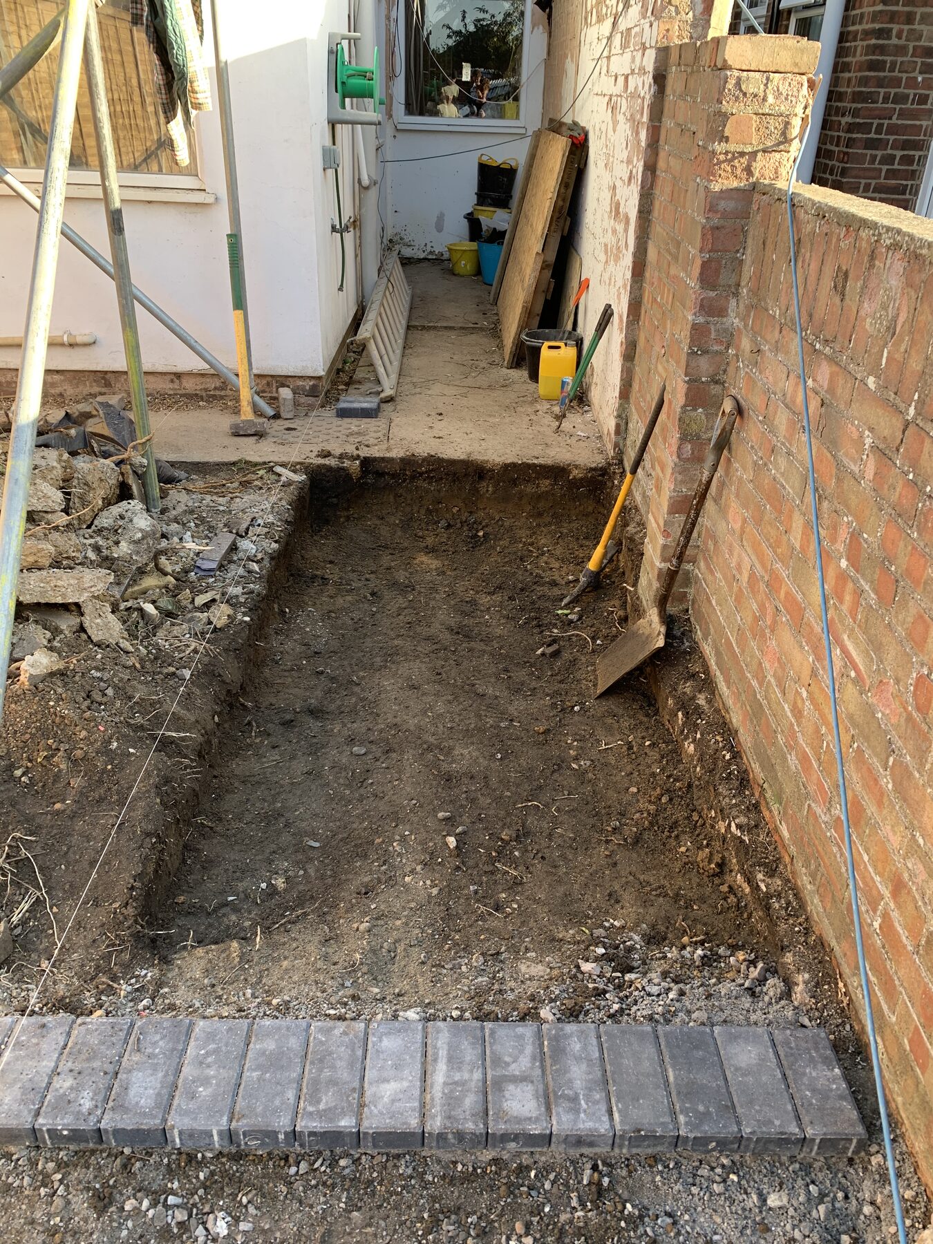Side pathway excavated with charcoal block paving border in Fletton