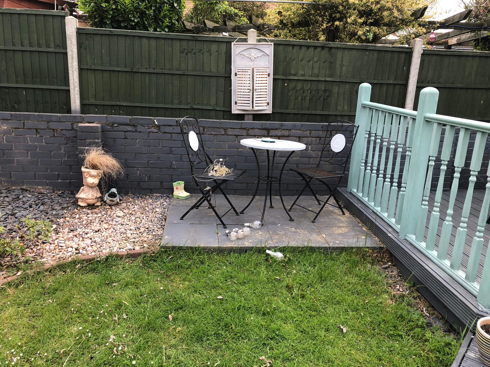 Old slab patio and tired fencing in Folksworth, Cambridgeshire before block paving installation