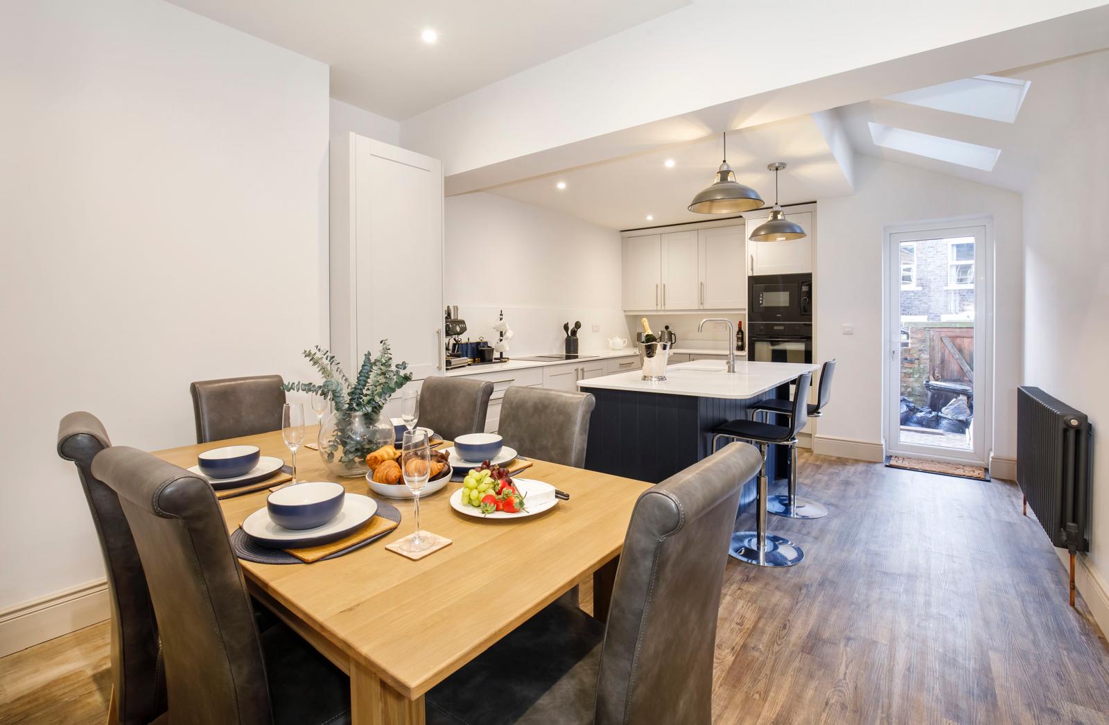 Finished open plan kitchen diner with dining table, island and Velux skylights in Cambridgeshire