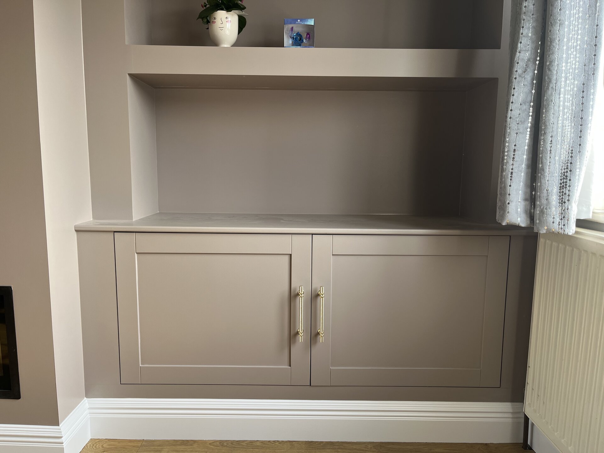 Detail of Shaker base cabinets with brass bar handles in painted media wall alcove