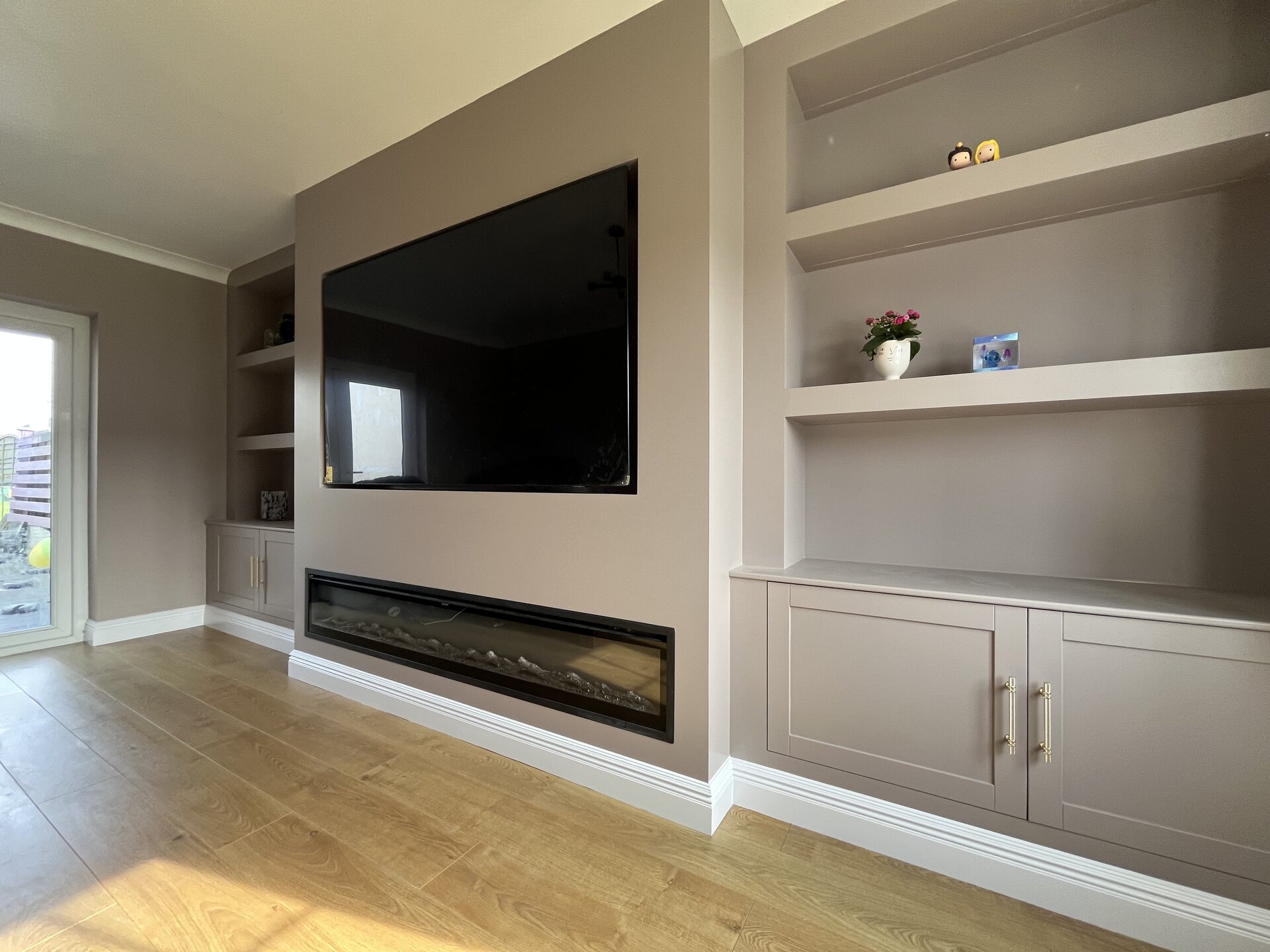 Completed bespoke media wall with 77-inch screen, electric fireplace and Shaker cabinetry in Sawtry, Cambridgeshire
