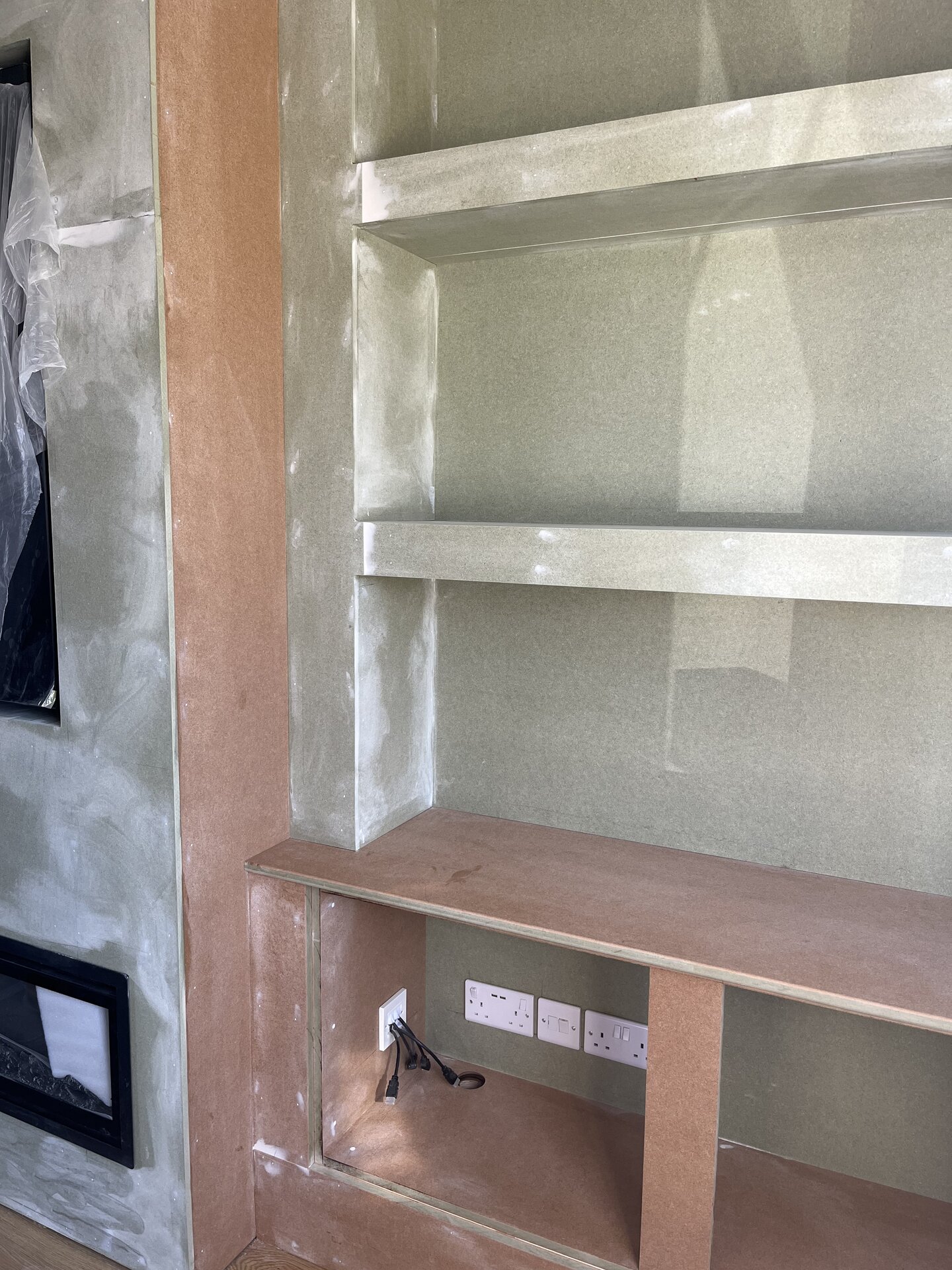 MDF cladding fitted to side alcove with shelves jointed flush ready for filler and paint