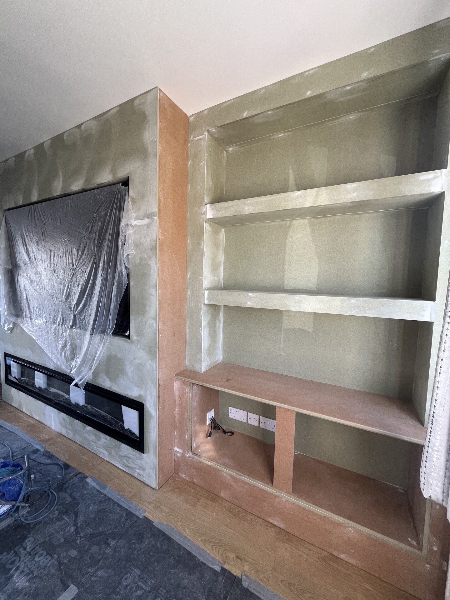 Filled and sanded MDF media wall with side alcove shelving ready for primer in Sawtry