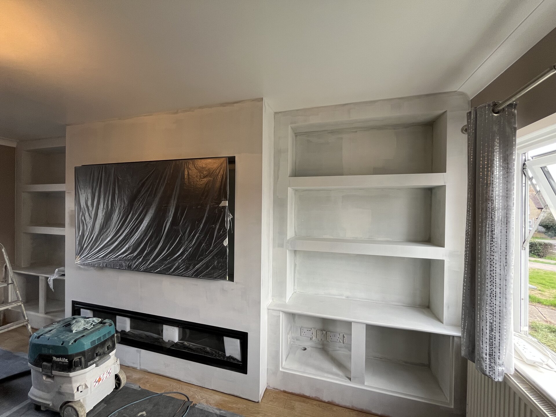 Bespoke media wall sprayed in mist coat with TV protected and fireplace masked off