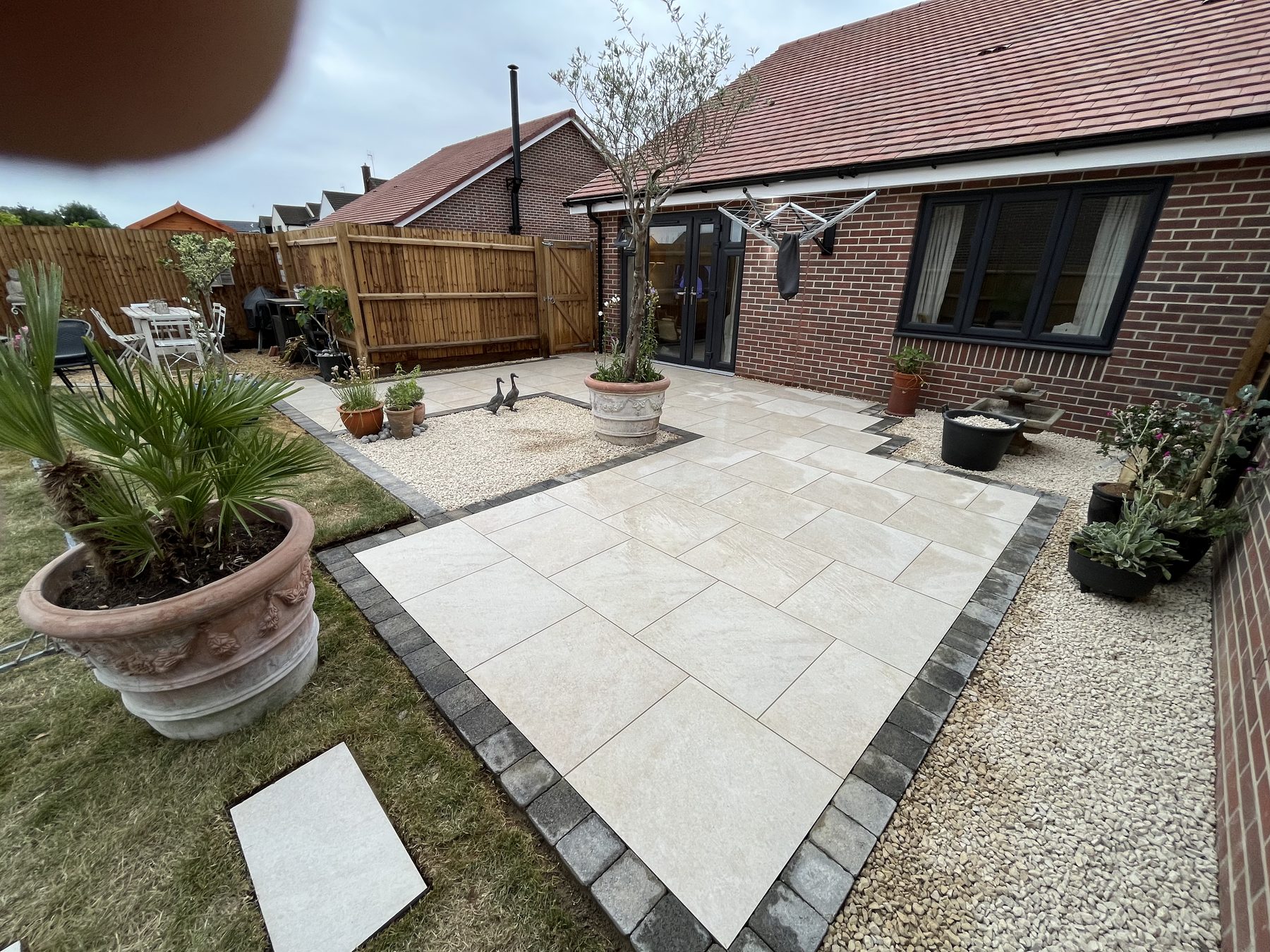 Finished large format porcelain patio with dark grey sett border in Stilton, Cambridgeshire