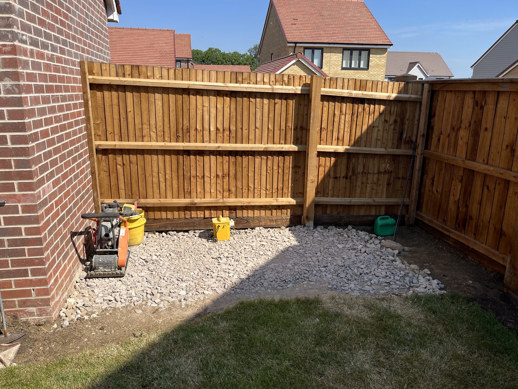 Laying the dark grey sett border for the porcelain patio in Stilton
