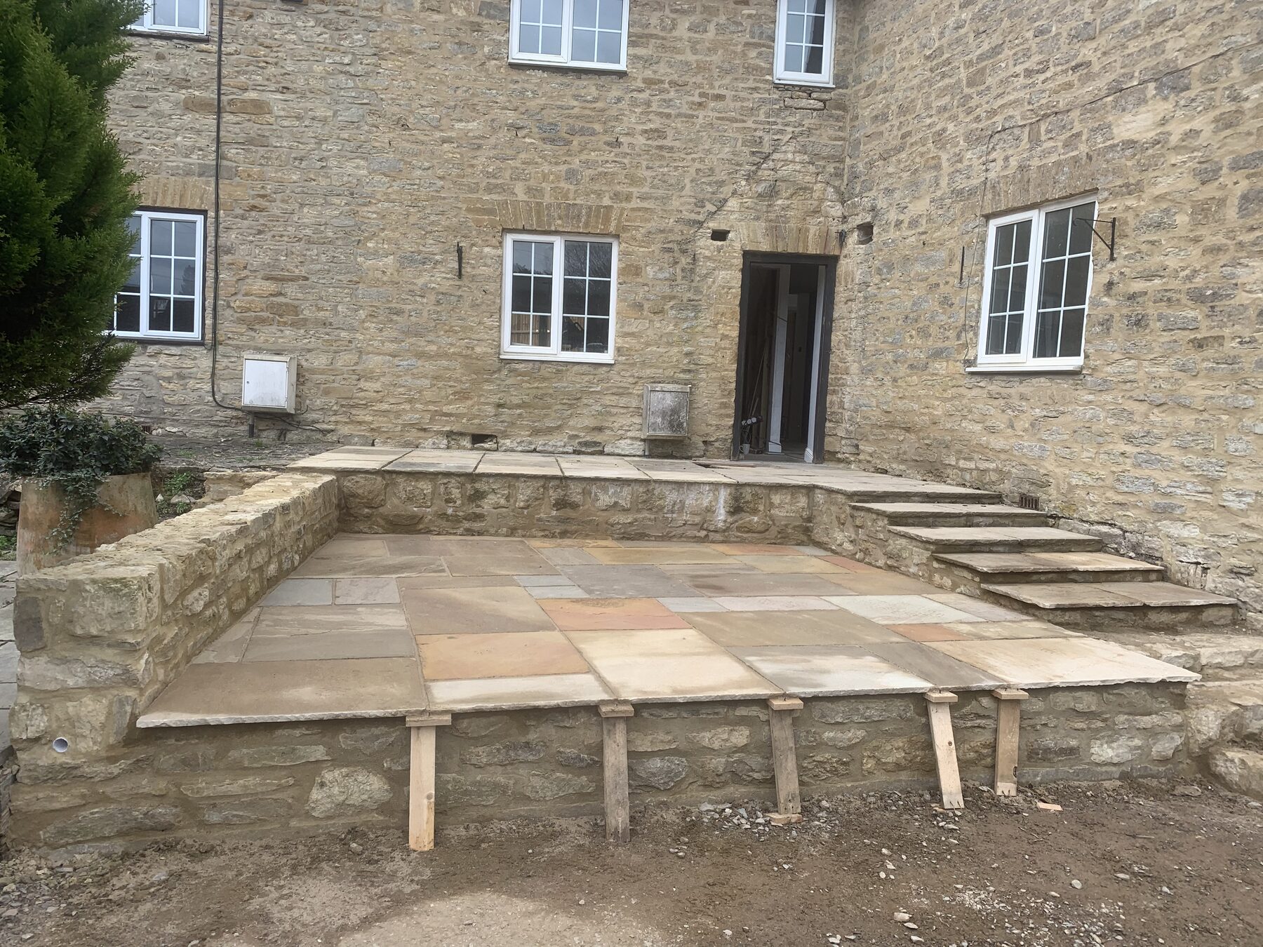 Wide view of newly laid reclaimed sandstone front patio with timber supports in Turvey, Bedfordshire