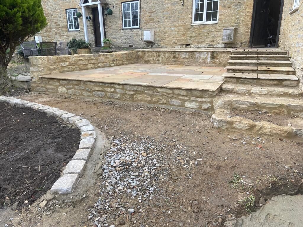 Newly laid reclaimed sandstone front patio on stone retaining wall in Turvey, Bedfordshire