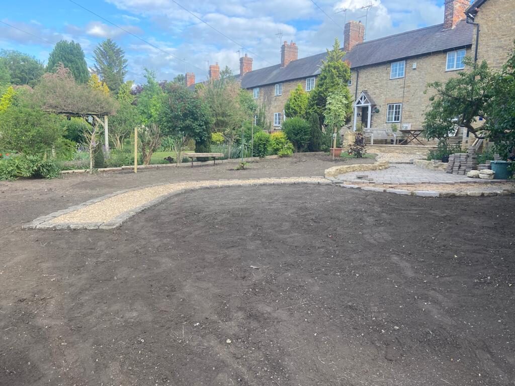 Rear garden mid-renovation with new gravel path, cobble edging and prepared lawn area in Turvey, Bedfordshire