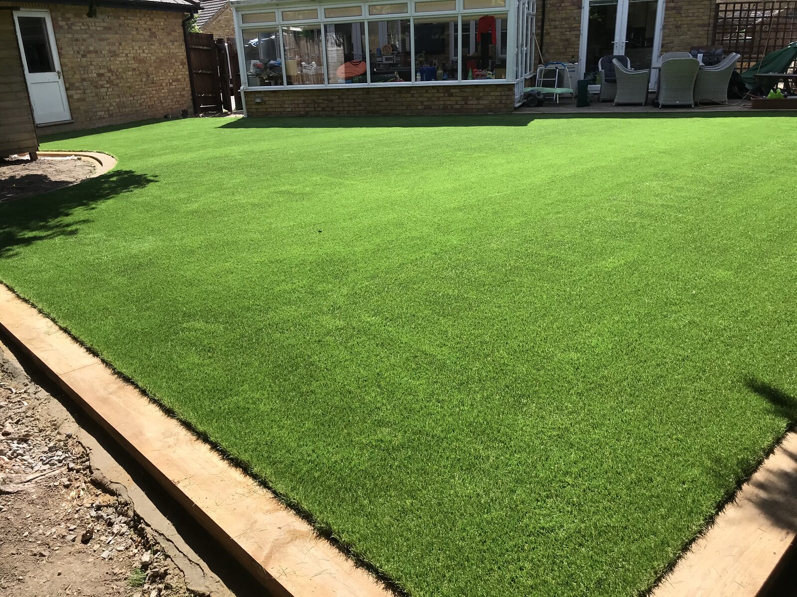 Lush, year-round artificial lawn installed in Turvey, Bedfordshire family garden by Arcadia Build & Landscape